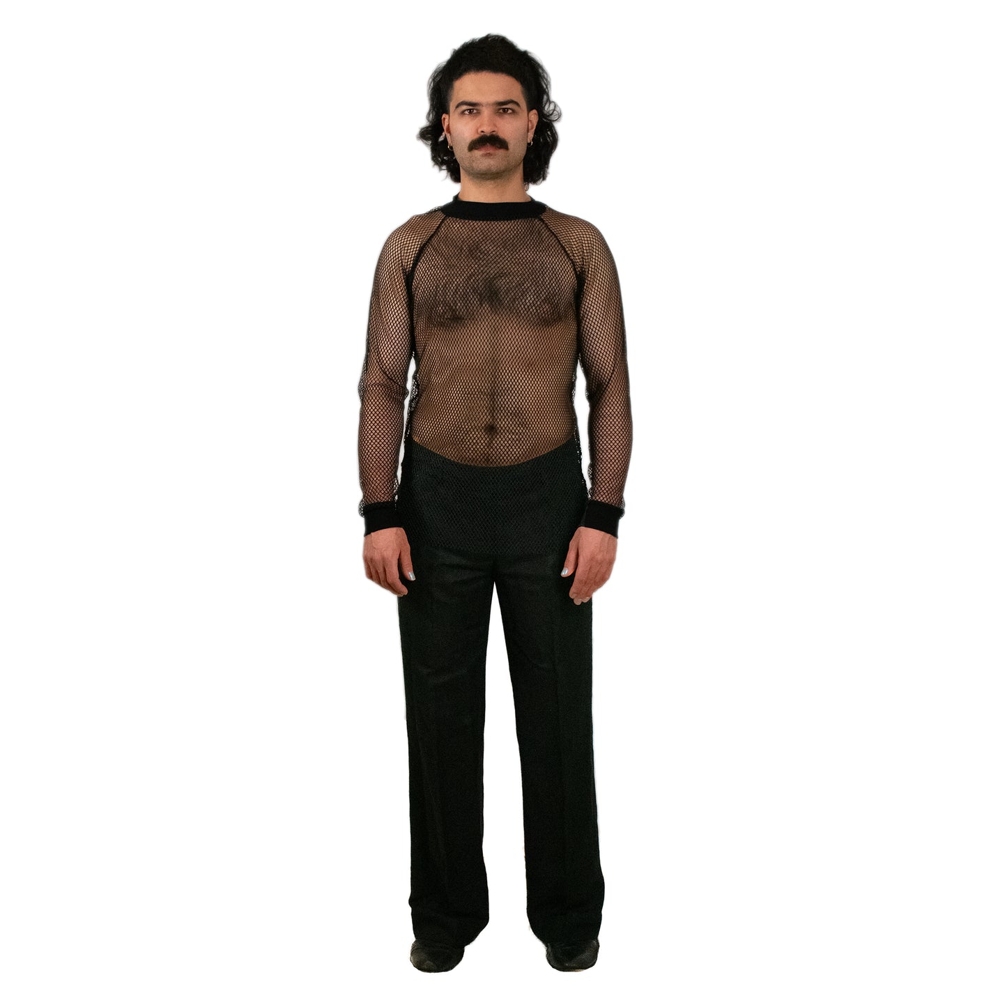 Man wearing a fishnet shirt over a black outfit on a white background